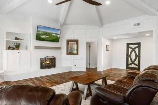 A brick fireplace with a large hearth expands to custom built-ins creating space for displaying treasured items and will surely warm the hearts of all that gather here!