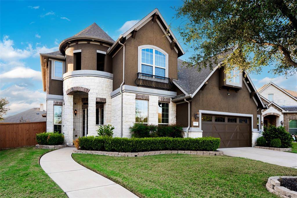 A charming mix of modern and traditional design, perfect for family living. The dark stucco exterior pairs beautifully with white stone accents and a landscaped front yard featuring low-maintenance shrubs. Arched windows and a wrought iron Juliet balcony add elegance, while the pitched roofline enhances character. The home includes a two-car garage with decorative accents and a spacious driveway. Situated in a quiet, well-maintained neighborhood, it blends curb appeal with functional living.