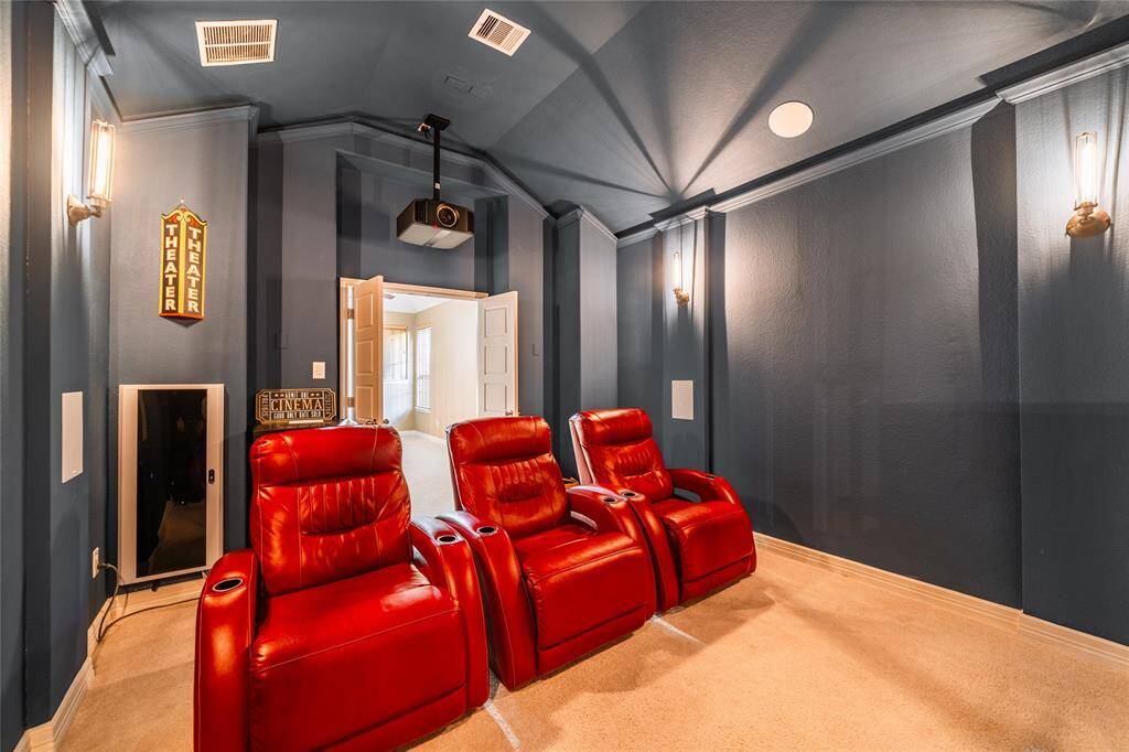 This luxurious private home theater is fully equipped for an unparalleled cinematic experience. It features a state-of-the-art projector, a large screen, and plush red recliner seating for ultimate comfort. The dark walls with elegant sconces create an immersive ambiance, while acoustic paneling ensures premium sound quality. Included with the home, this theater is perfect for movie nights or gaming.