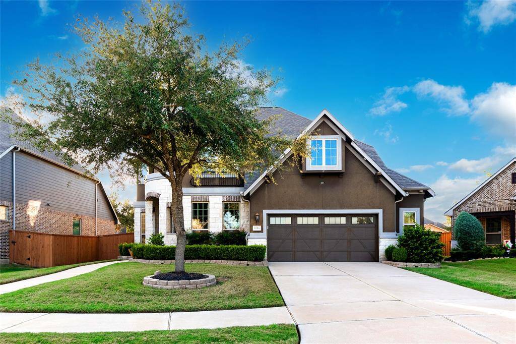A charming mix of modern and traditional design, perfect for family living. The dark stucco exterior pairs beautifully with white stone accents and a landscaped front yard featuring low-maintenance shrubs. Arched windows and a wrought iron Juliet balcony add elegance, while the pitched roofline enhances character. The home includes a two-car garage with decorative accents and a spacious driveway. Situated in a quiet, well-maintained neighborhood, it blends curb appeal with functional living.