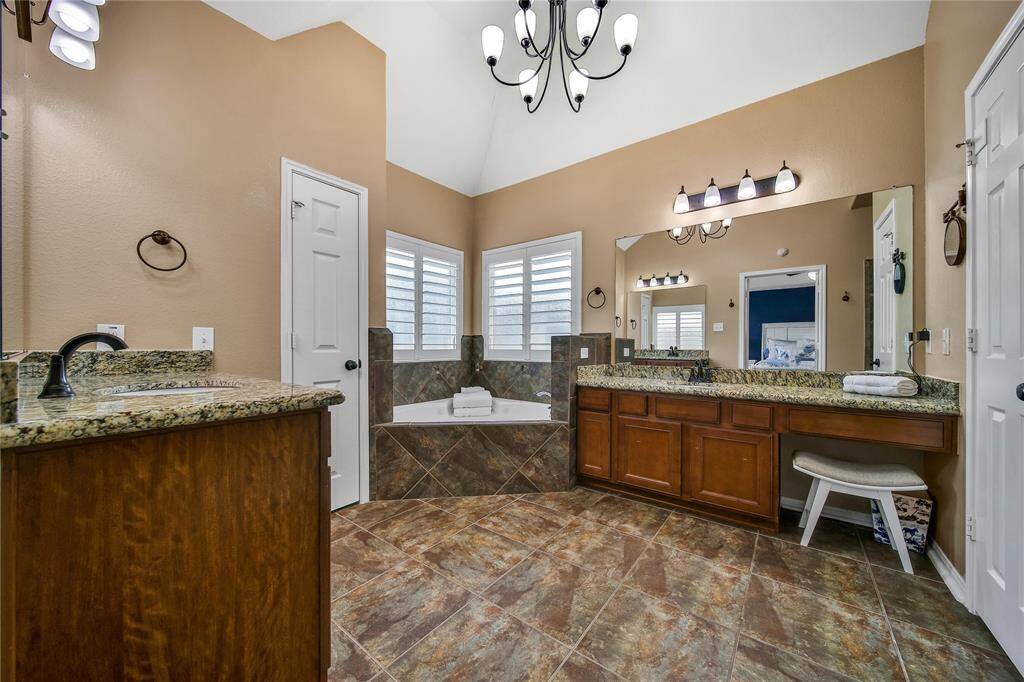 spacious primary bathroom with soaking tub, stand alone shower, vanity and dual sinks.  Updated fixtures highlight this primary bathroom.