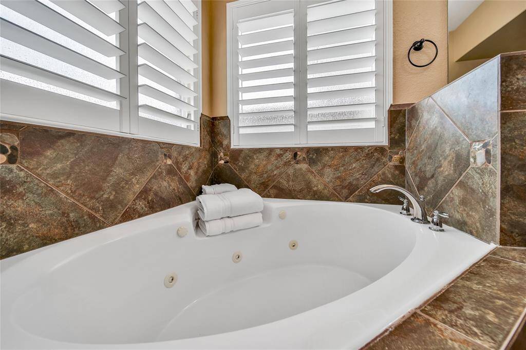 Soaking tub with jacuzzi jets for relaxation in this primary bath
