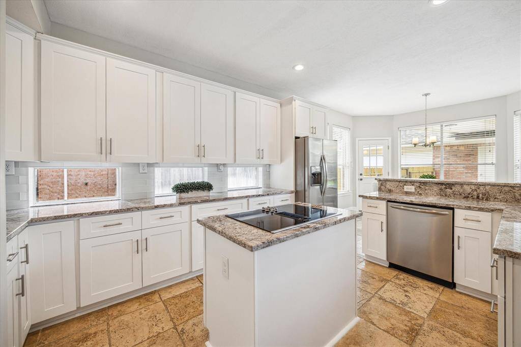 Updated white cabinets and glass subway tile backsplash give the kitchen a clean, crisp look.
