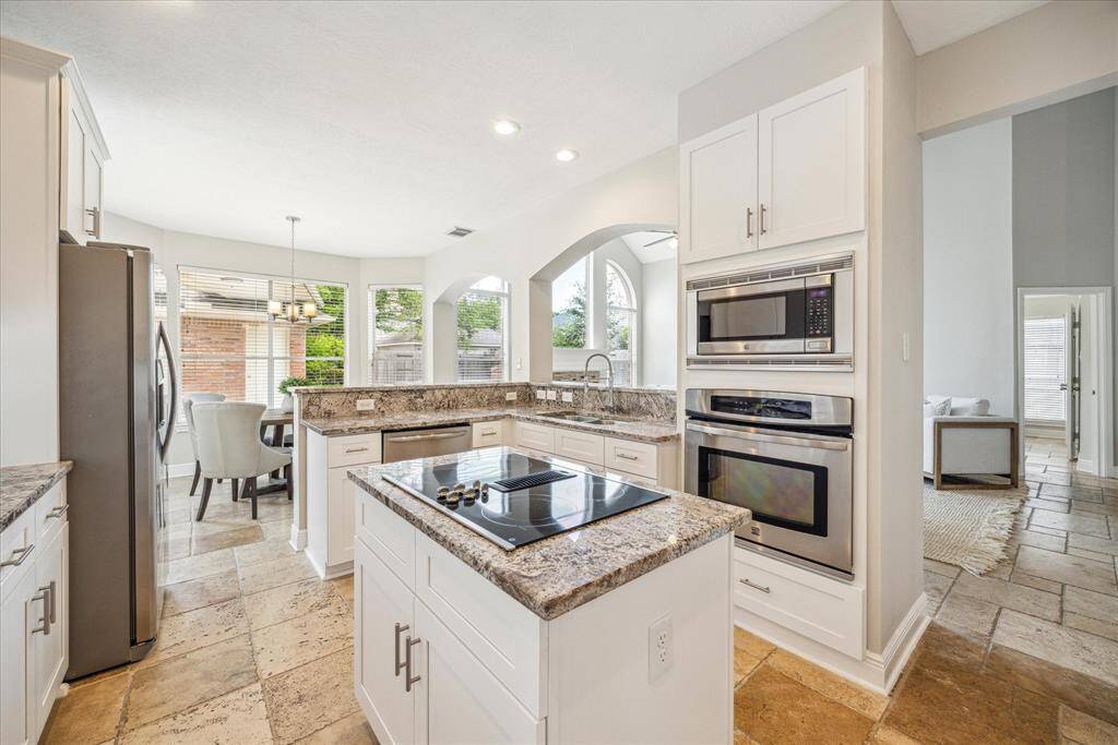 Gorgeous granite countertops, stainless steel appliances and center island. The double doors open to the pantry and the door on the right leads to the laundry room.