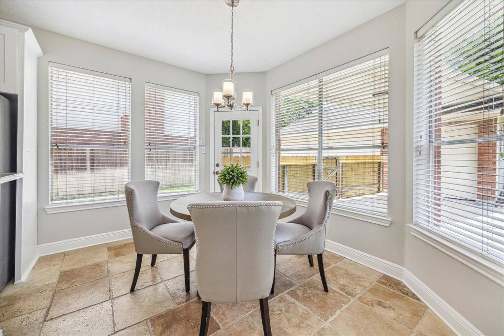 The breakfast room has large windows that bring in abundant natural light and is perfect for enjoying your morning coffee or enjoying a casual meal. The door leads to the backyard.
