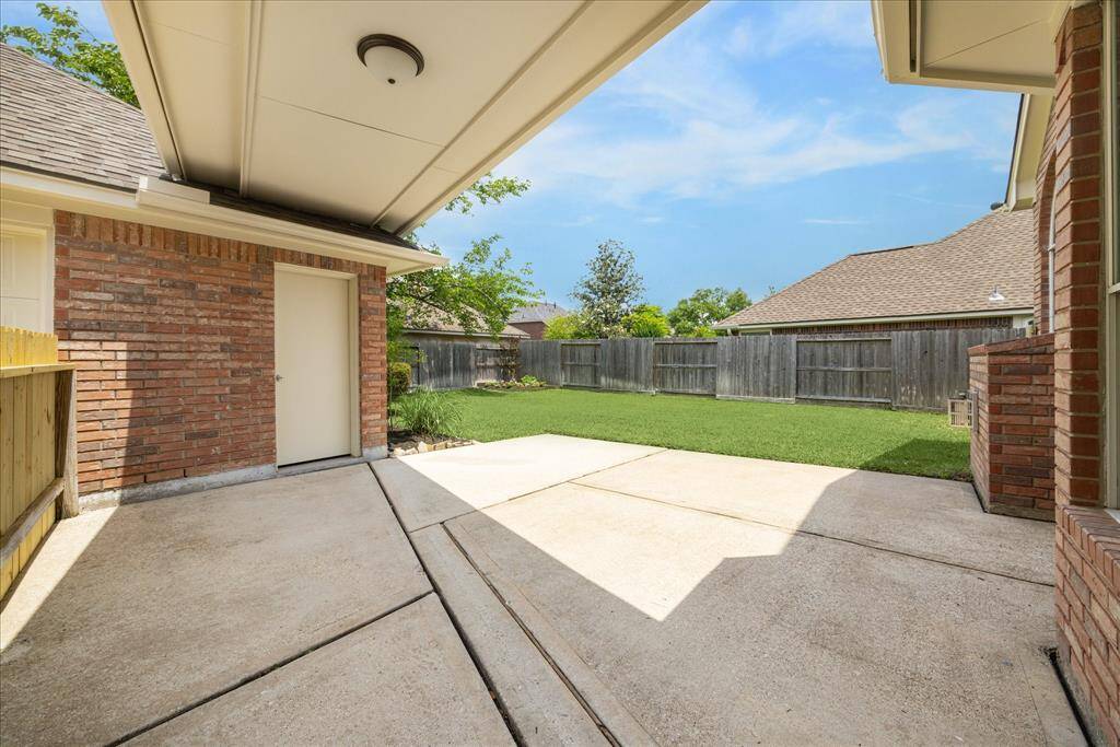 Stepping outside, a breezeway connects the house to the detached garage. The large patio is the perfect place to set up your grill & outdoor dining table or creating an outdoor sitting area.