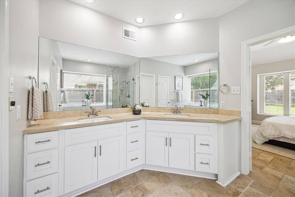 The primary bathroom is a luxurious retreat, bathed in natural light and designed for both comfort and elegance. Crisp, neutral tones create an airy, spa-like atmosphere.