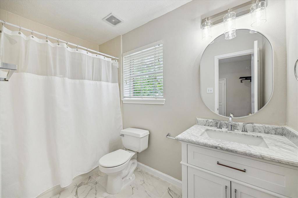 The ensuite bath offers a tub/shower combo with light neutral colors.