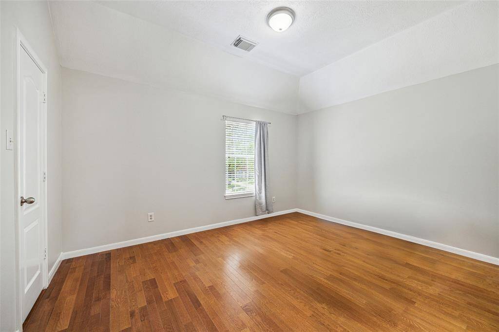 Secondary bedroom upstairs with hardwood flooring.