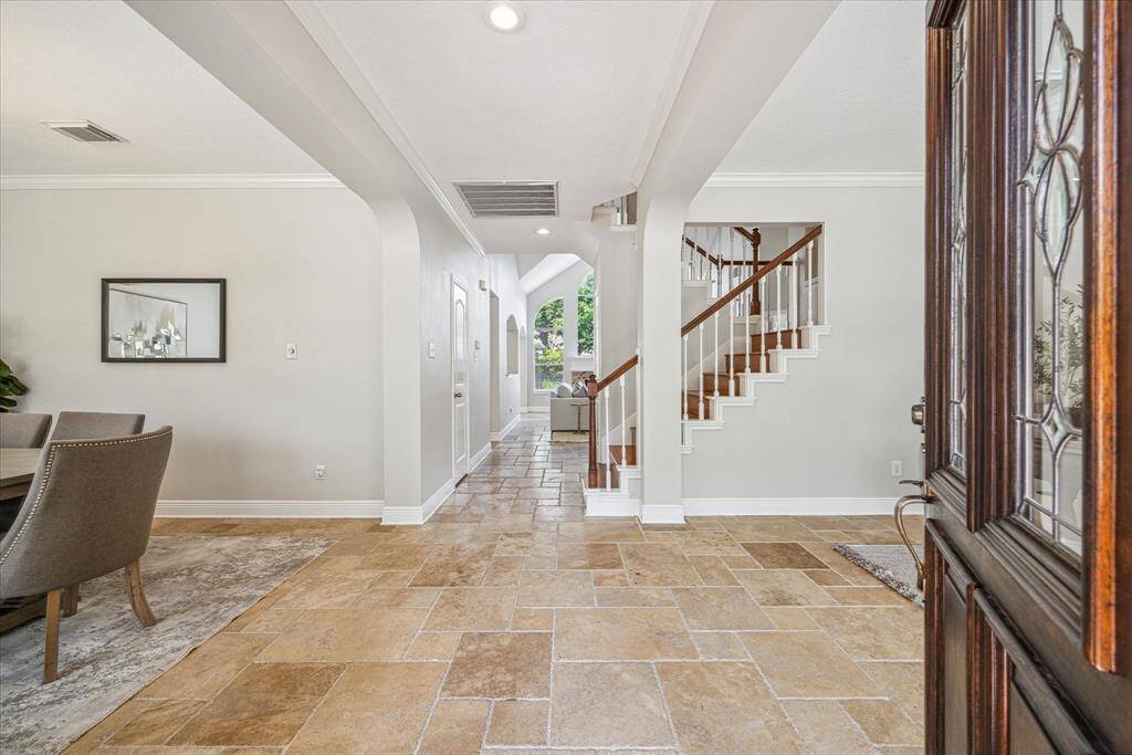 Gorgeous travertine flooring flows through the first floor while high ceilings are accented with crown molding.