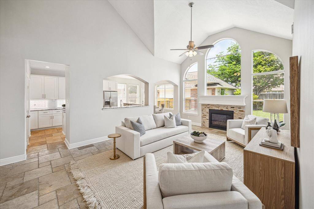 A wall of windows fills the grand vaulted 2-story family room with natural light while the stacked stone fireplace with white mantle creates a focal point in the room. The family room opens to the kitchen & breakfast room creating a great space for entertaining.