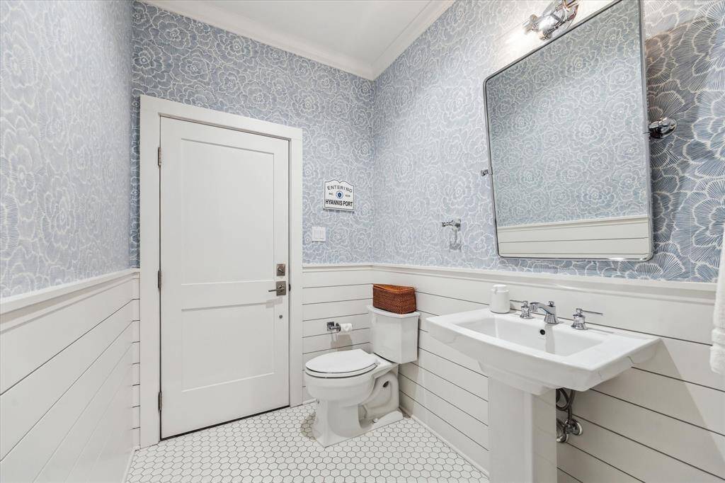 This cheerful powder bath is impossible not to smile at! With access from both inside the home and the screened-in porch, it’s the perfect poolside bathroom. Stylish wallpaper and shiplap wainscoting add a charming, designer touch.