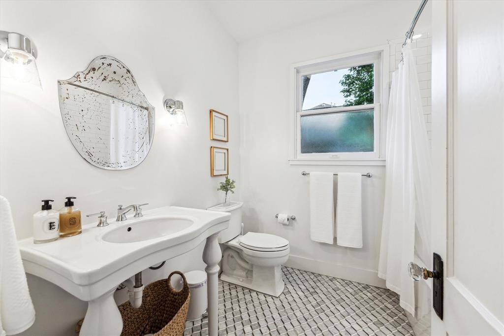 Full bathroom on the first floor with marble tile and a shower/tub combo.
