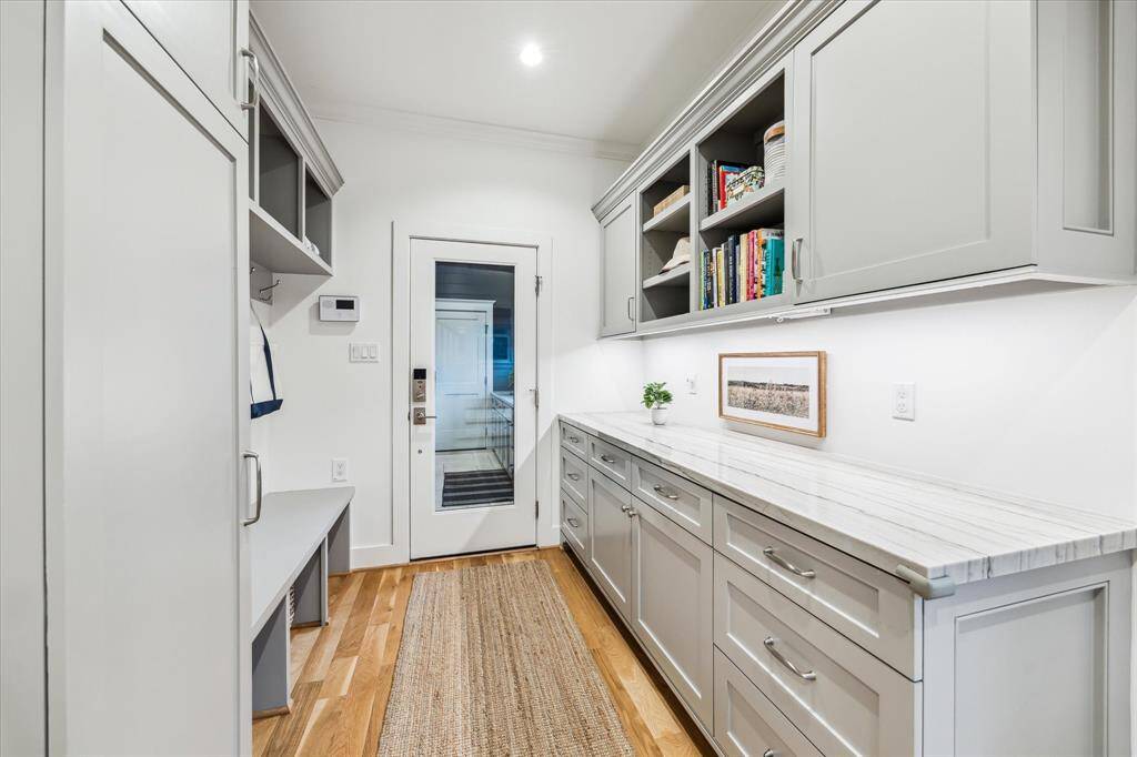 Mudroom with quartzite countertop, storage and hooks to help keep everything organized.