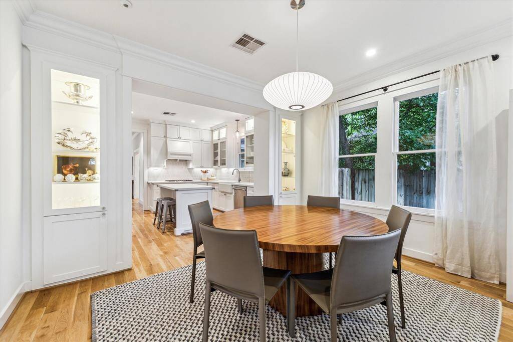The dining room is anchored by a nelson saucer bubble pendant by Herman Miller and two custom built-in cabinets and is bathed in natural light from the two large windows.