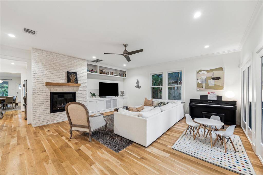 Additional view of the family room with the gas log fireplace and built-in shelves and storage.