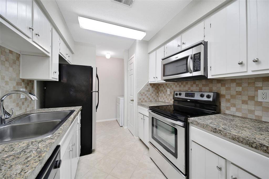 Stainless steel appliances in kitchen with in unit laundry access