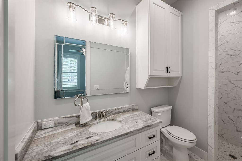 2nd bedroom ensuite bath with leathered granite tops and custom walk-in shower.