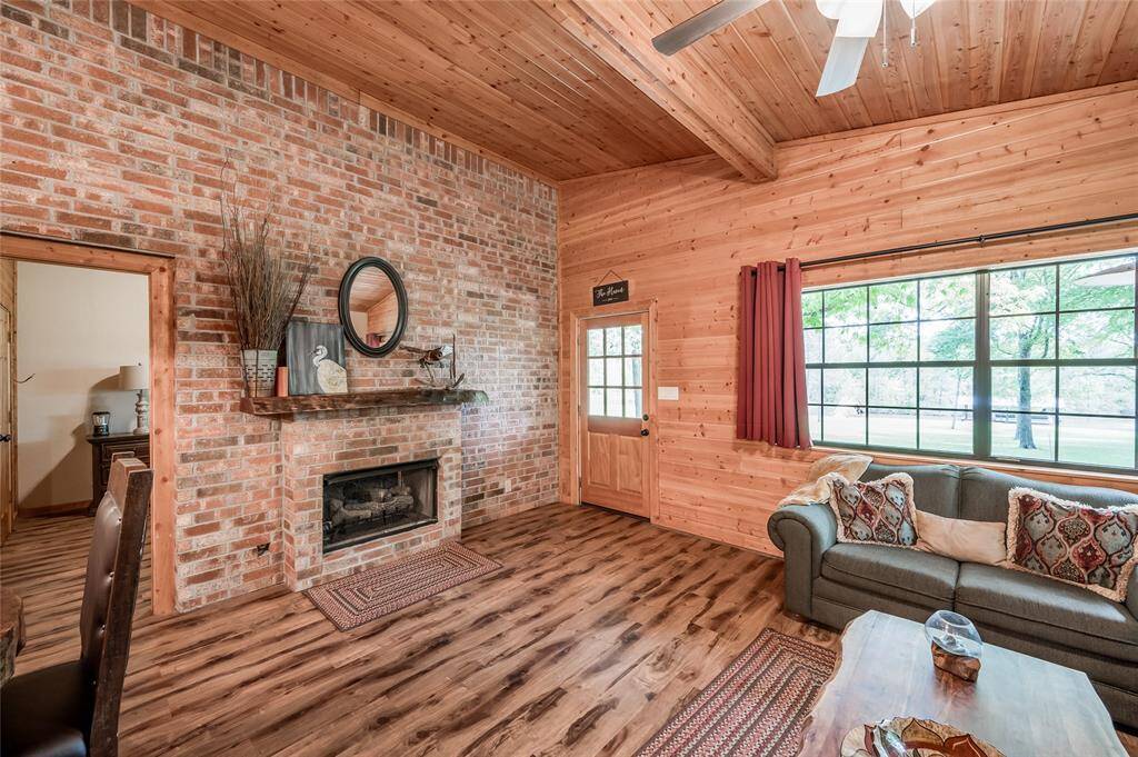 Between the living room and primary bedroom, there is also a brick accent wall with a double-sided fireplace.