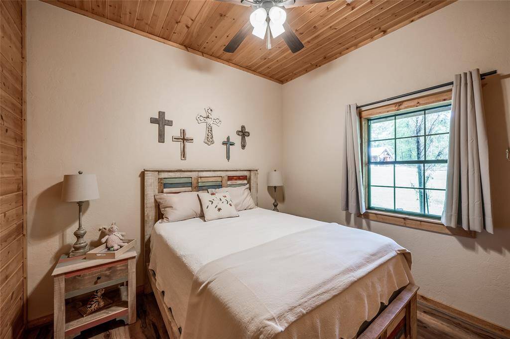 2nd bedroom with tall ceilings and wood accents.