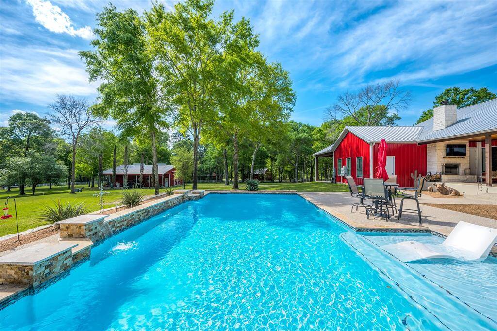 Backyard pool oasis that features a sundeck and waterfalls.