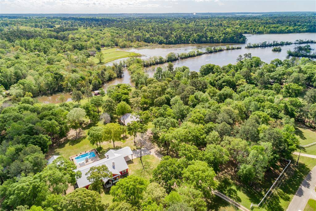Aerial view of the main house, guest house, land, and lake.