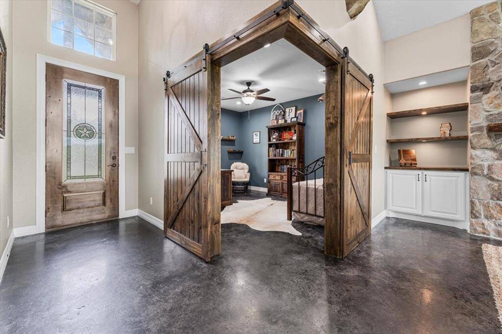 This welcoming entryway leads to a room through charming barn-style sliding doors. The space is versatile, it can certainly be used as an office, flex-room, craft room, exercise room, or additional bedroom.