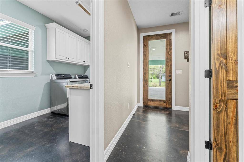 The laundry area is off the kitchen and near the carport entry door.