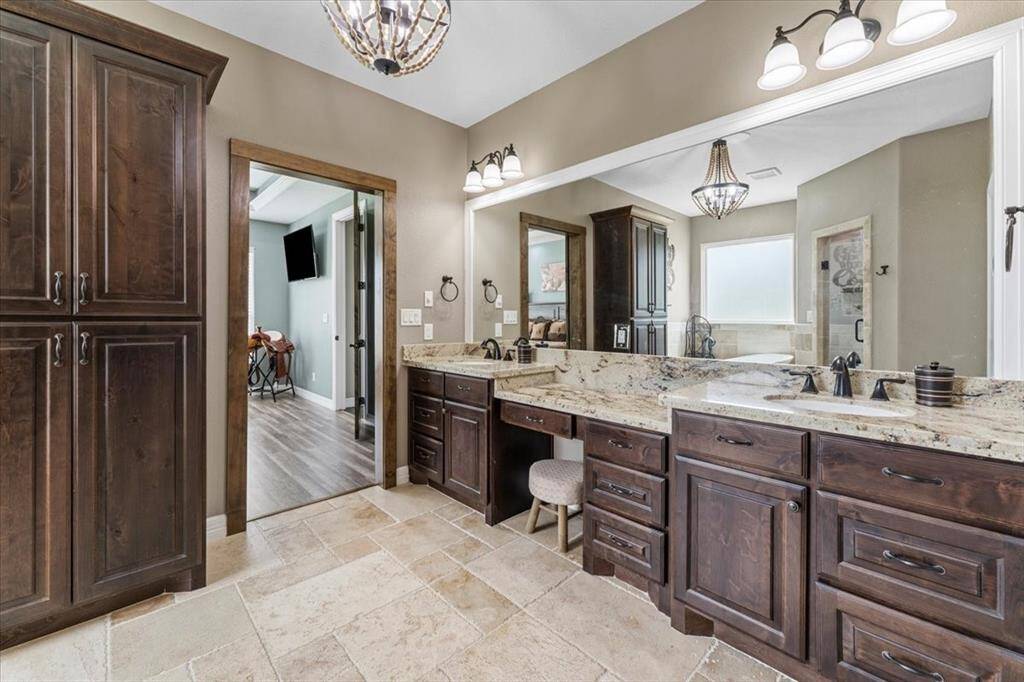 The primary suit bath is equipped with lots of cabinetry for storage.