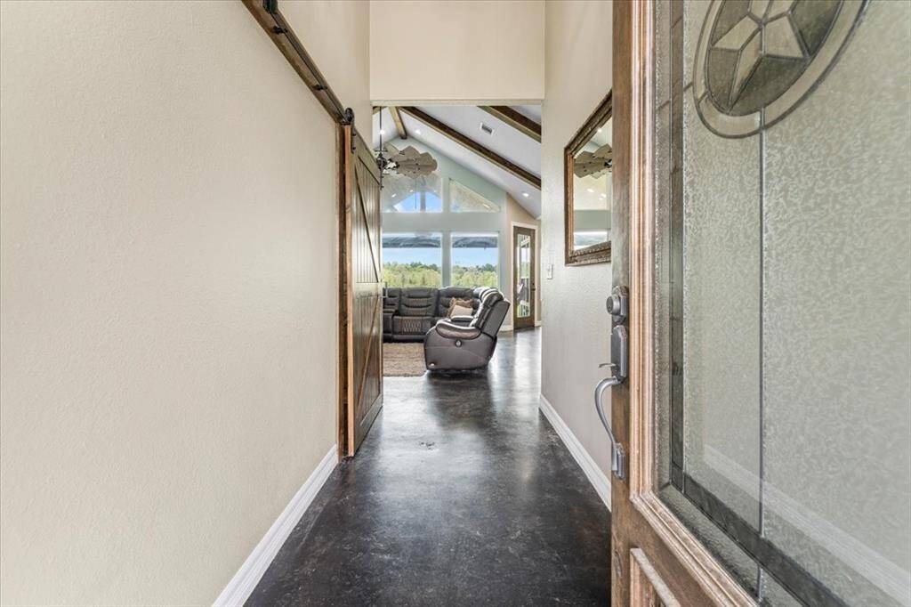 As you enter you are met with a wood door featuring a Texas Star etched into the glass, with stained concrete floors throughout.