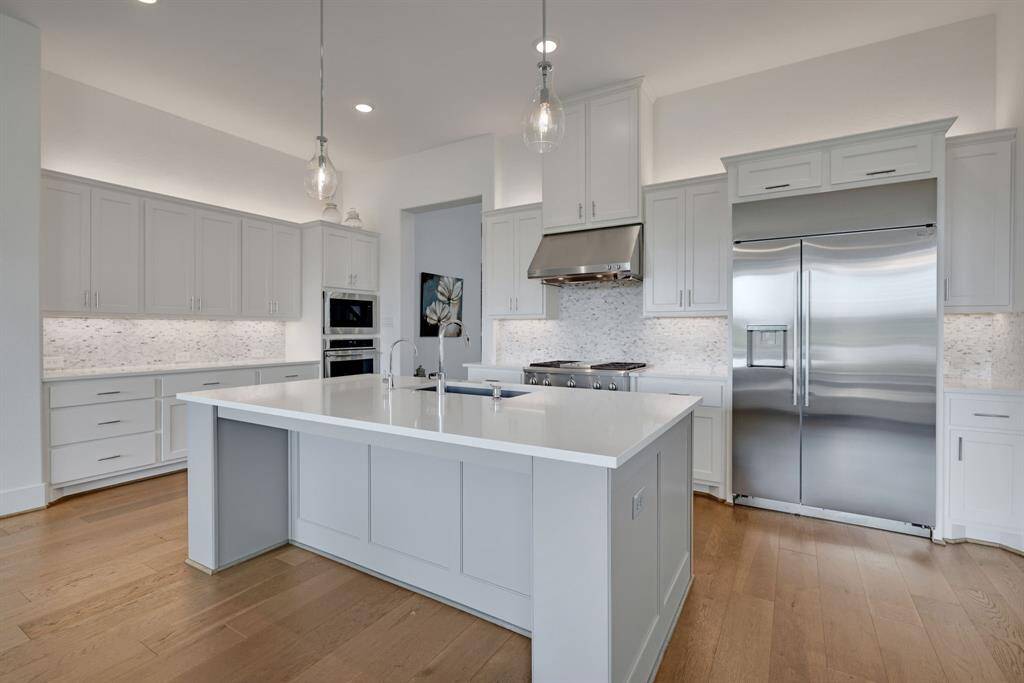 This stunning kitchen features a large island and GE Monogram appliances, including a professional 36" gas range, venthood, dishwasher, oven, microwave, and a 42" built in side by side refrigerator.