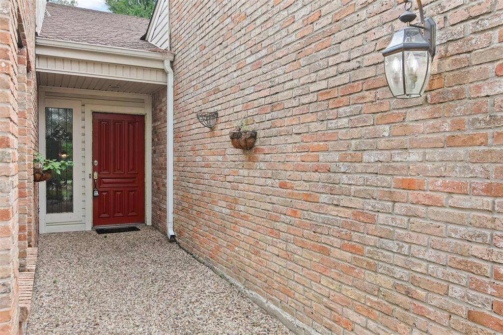 Entry to the front door is spacious with brick wall surround and pebbled walkway.
