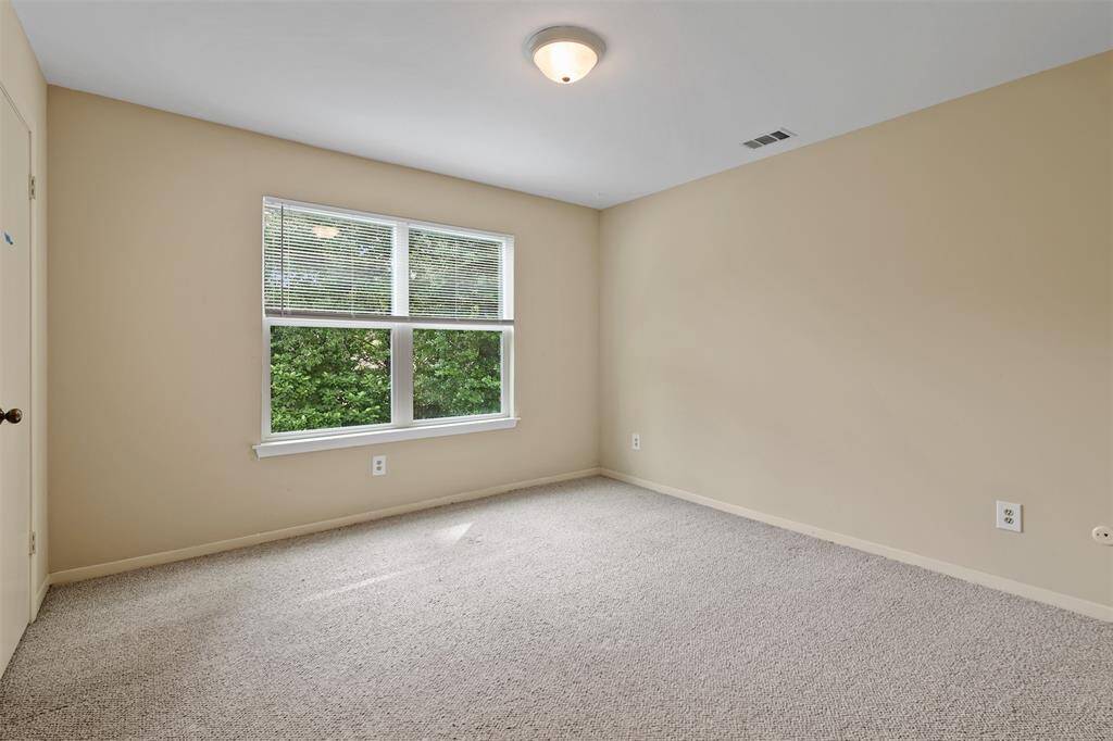 Third secondary bedroom upstairs with carpet and window.