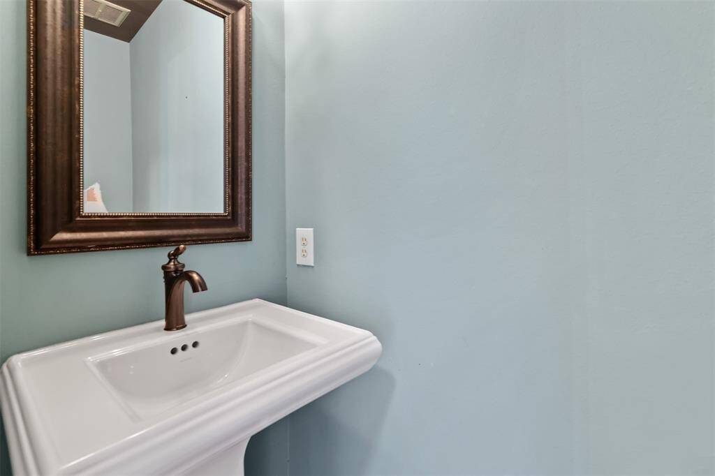 Half bathroom downstairs with pedestal sink.