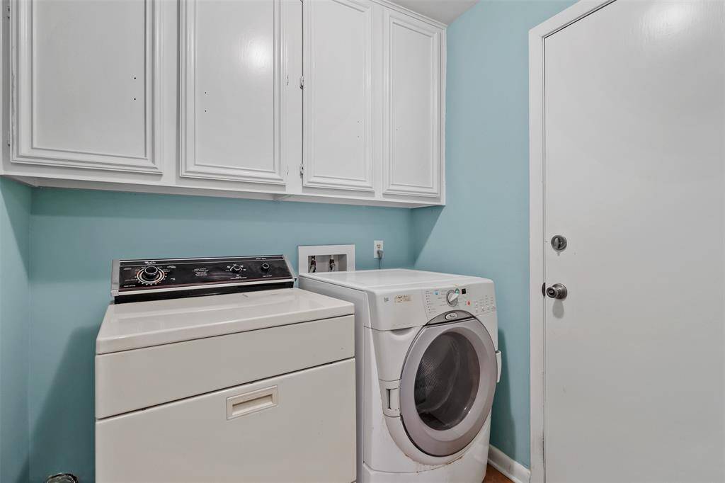 Utility room in house has built in cabinets and access to the garage.