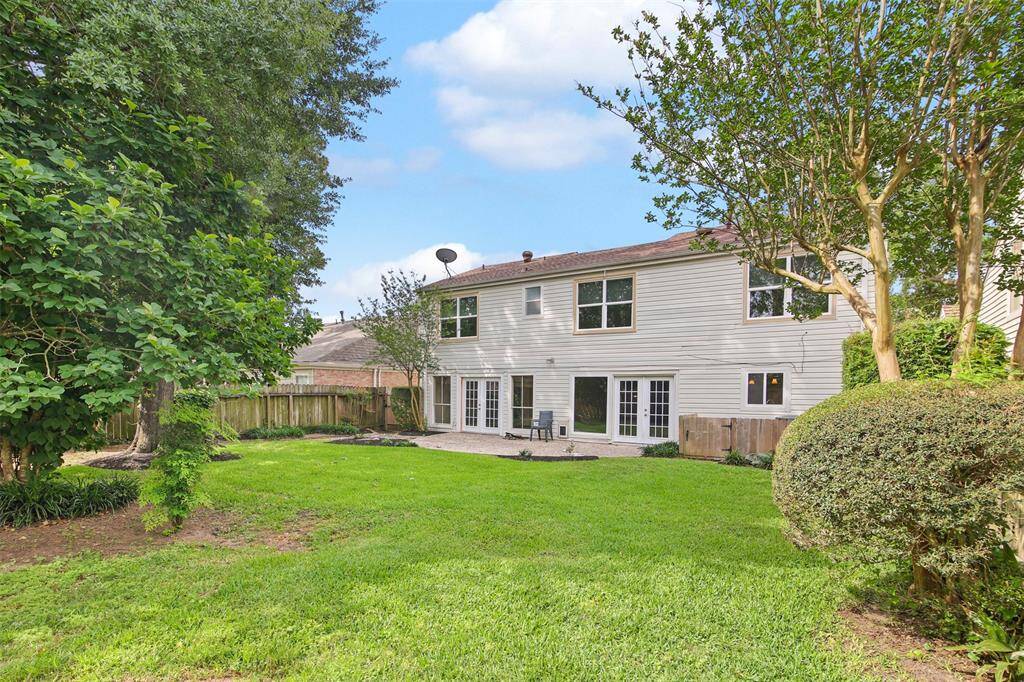 Backyard of home features professional landscaping and plenty of green space for the kids and pets to play.