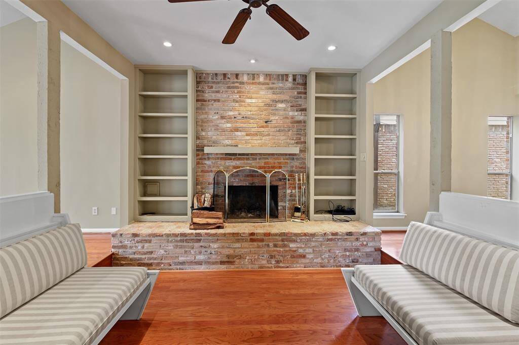 Formal living room seating area has wood burning fireplace with built ins surrounding.