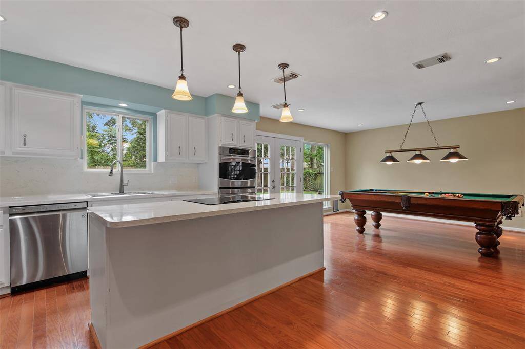Kitchen features an island with breakfast bar, pendant lighting and plenty of storage space.