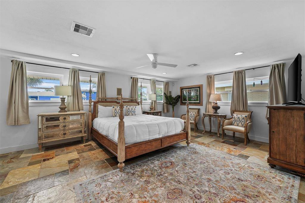 This large primary bedroom located on the first floor offers tons of light from multiple windows