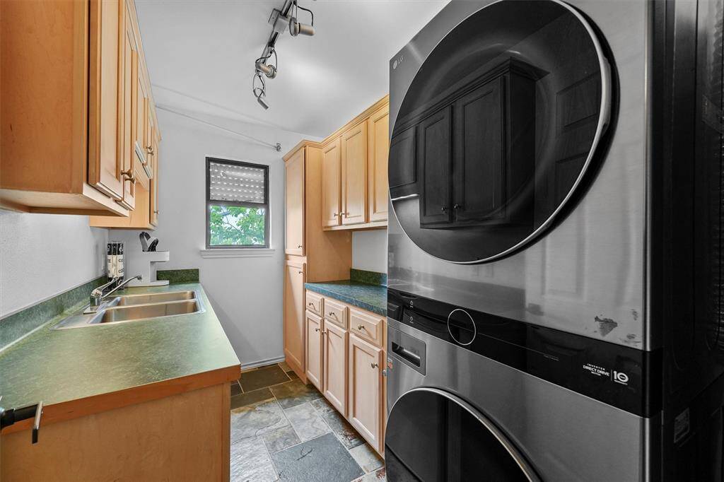 This functional utility space features built-in cabinetry and a sink, offering practical storage and convenience.