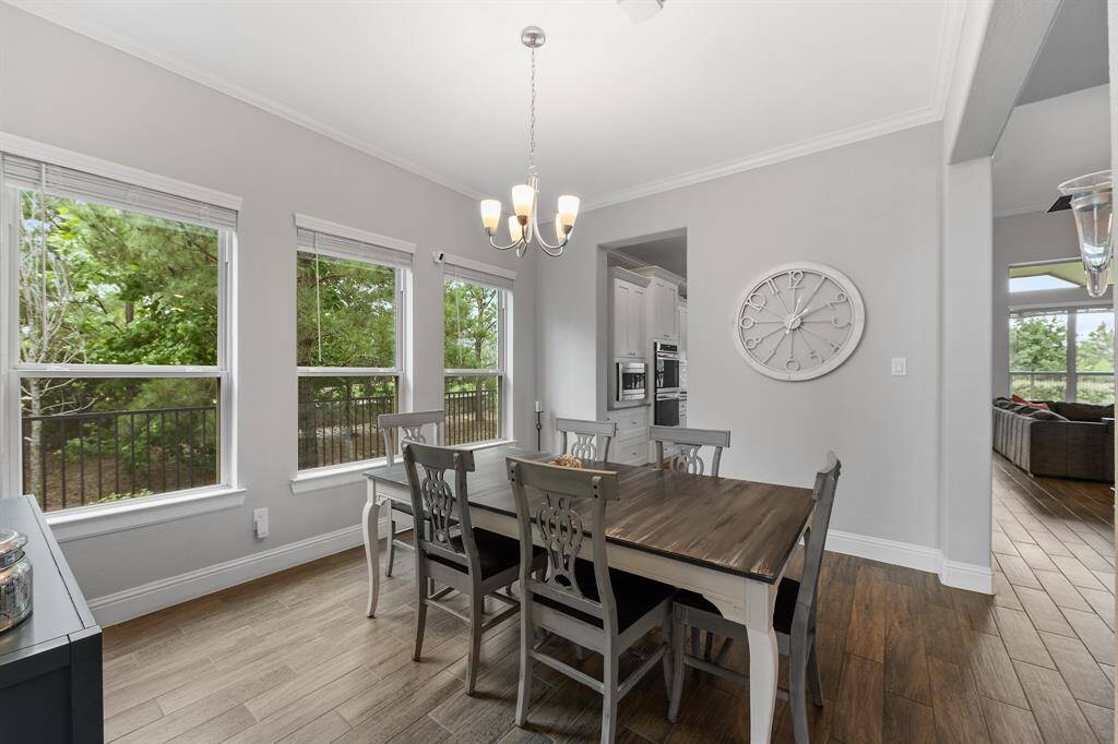To your left as you enter home, the dining room exudes warmth with rich dark wood tones coming from the rich dark tile flooring and the table, providing a uniquely cozy ambiance.