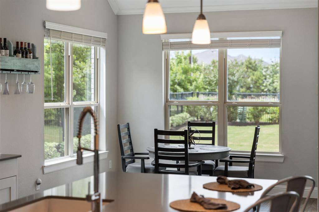 The cozy breakfast nook rests just beside the kitchen surrounded by tall windows and bright natural light for maximizing comfort and familiarity.