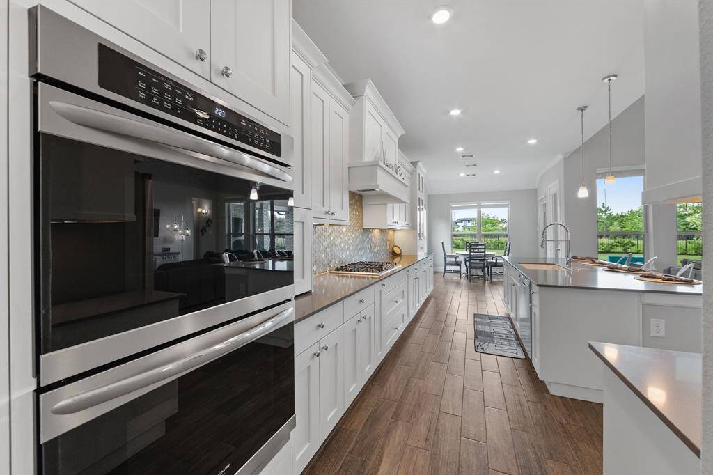 The family room features a stunning glass fireplace with tall walls, creating a striking focal point. Ample space for relaxation is enhanced by large windows offering a beautiful backdrop of the yard, bringing the outdoors in.