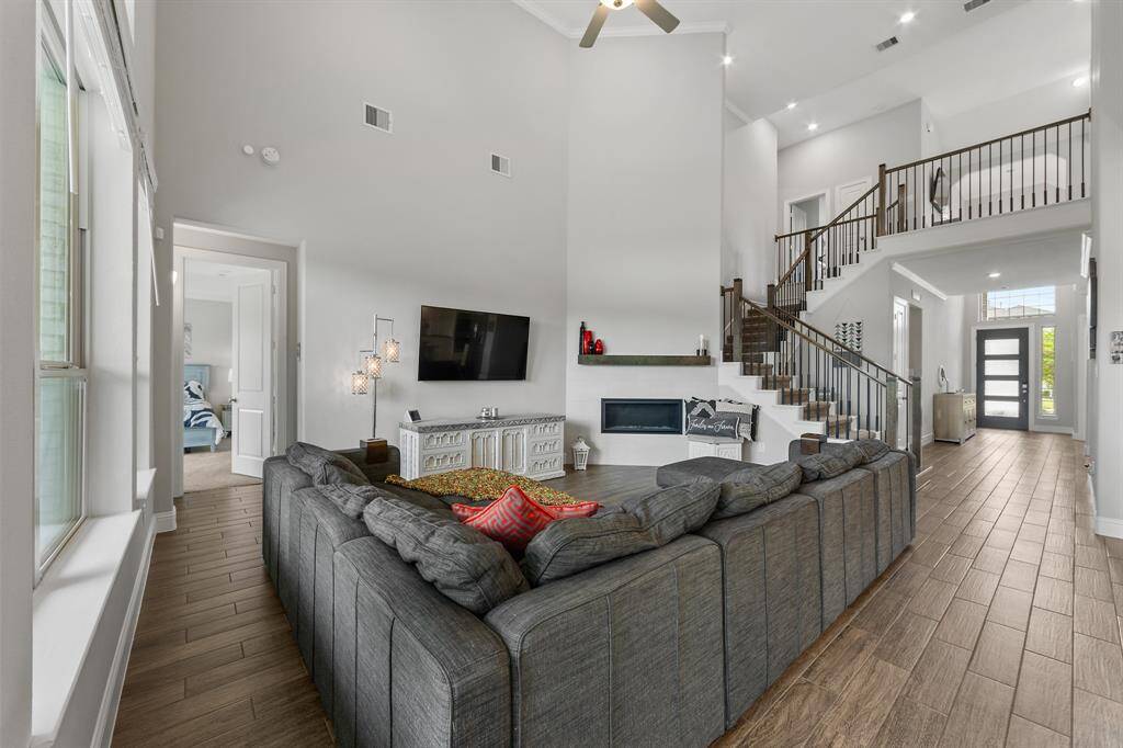 The spacious primary bedroom features a beautiful tray ceiling with recessed lighting and a ceiling fan, adding depth and elegance to the room. Three large windows frame serene backyard views, filling the space with natural light and a peace. It sits right next to family room.