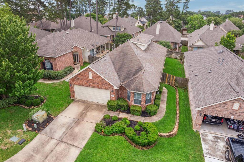Aerial view showcasing the beautiful surroundings of this home nestled in the acclaimed Bentwater neighborhood, featuring a stunning brick exterior that enhances its timeless charm.