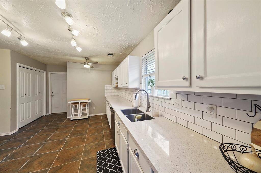 The kitchen features custom lighting and granite countertops