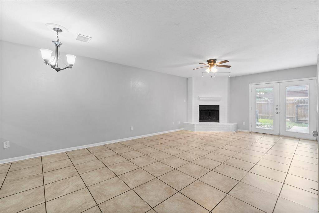 Open and spacious living area with fireplace and view of the backyard.