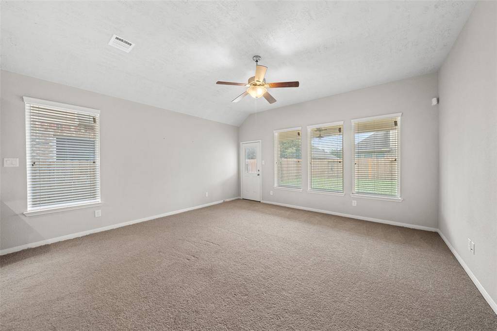 Living Space. Den or Family Room looking out towards back of home & Yard; door at back leads out to covered patio and fully sprinkled Backyard. Has a ceiling fan to keep you cool in the summer, and ready for that Chef and BBQ!