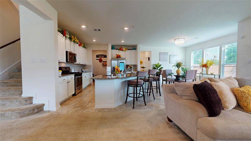 This is where the timeless open floor plan design concept is most appreciated: unobstructed room space meets common space. The living room is on the right, the kitchen, the breakfast nook, the powder room is ahead, and the wide staircase is on the left.