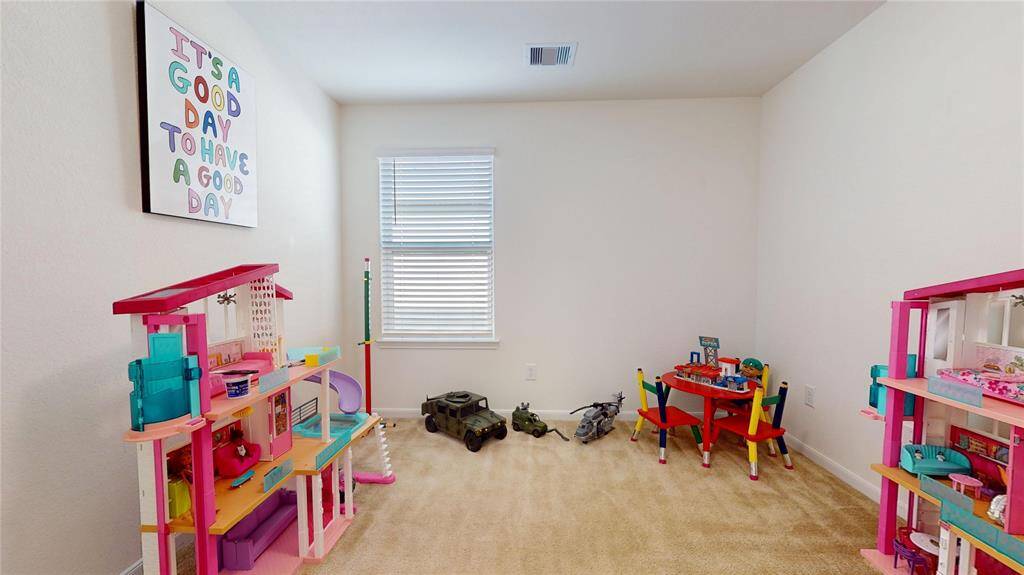 Third carpeted bedroom being used as an ideal playroom.